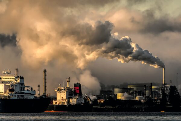 Landscape Photograph of smoke stack emissions over a harbor into a cloudy sky