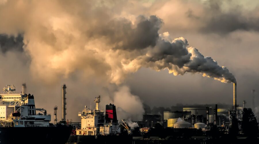 Landscape Photograph of smoke stack emissions over a harbor into a cloudy sky